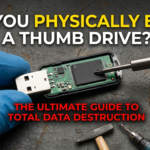 A person wearing blue protective gloves holding a disassembled USB thumb drive on a dark, textured workbench. A small precision screwdriver points toward the black NAND flash memory chip on the circuit board. In the background, a small hammer, a drill bit, and a mini-shredder with paper strips are visible. Bold text overlays the image: "CAN YOU PHYSICALLY ERASE A THUMB DRIVE? THE ULTIMATE GUIDE TO TOTAL DATA DESTRUCTION."